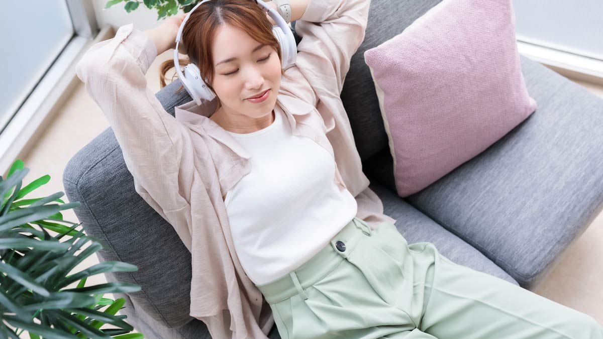 夜勤の仕事を終えた20代女性が、施術後にソファで安心してリラックスしているイメージ